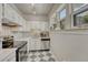 Charming kitchen with white cabinets, checkerboard floors, and stainless steel appliances at 1100 N Marion St # 4, Denver, CO 80218