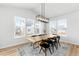 Bright dining room with a wooden table, black chairs, modern chandelier, and large windows at 777 Gold Hill Dr, Erie, CO 80516