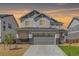 Inviting two-story home with a two car garage and stone accents against a sunset sky at 777 Gold Hill Dr, Erie, CO 80516