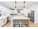 Bright, open kitchen with white cabinets, large center island, and stainless steel appliances at 777 Gold Hill Dr, Erie, CO 80516