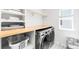 A laundry room featuring a stacked washer and dryer, counter space and shelving at 777 Gold Hill Dr, Erie, CO 80516