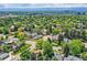 Stunning aerial view of a neighborhood with mature trees, manicured lawns, and breathtaking mountain views at 2 Elm St, Denver, CO 80220