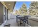 Covered balcony features a table and chairs with a lovely view of mature evergreens at 2 Elm St, Denver, CO 80220