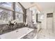 This stylish bathroom includes a soaking tub, vanity, and large, bright windows at 2 Elm St, Denver, CO 80220