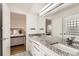 Bright bathroom features a granite vanity, white cabinets, and decorative glass block window at 2 Elm St, Denver, CO 80220