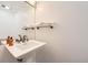 Well-lit half bathroom featuring a pedestal sink, mirror, and a glass shelf holding soft white towels at 2 Elm St, Denver, CO 80220