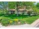 Beautifully landscaped front yard featuring a flower bed and mature trees providing shade at 2 Elm St, Denver, CO 80220