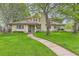 Inviting home with a lush green lawn and a curved pathway leading to the front door at 2 Elm St, Denver, CO 80220