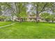 Lush front lawn with mature trees leading up to the inviting home facade at 2 Elm St, Denver, CO 80220