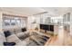 Spacious living room featuring hardwood floors, a sectional sofa and seamless flow into the kitchen and dining area at 2 Elm St, Denver, CO 80220