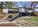 Exterior view of home and backyard showing brick foundation, covered patio, sunroom and terraced landscaping at 6948 W 70Th Ave, Arvada, CO 80003