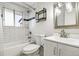 Clean bathroom with tiled shower-tub, modern vanity, and a sliding window at 6948 W 70Th Ave, Arvada, CO 80003