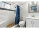 Bright remodeled bathroom featuring white subway tile shower, unique mosaic floor, modern vanity, and updated fixtures at 6948 W 70Th Ave, Arvada, CO 80003