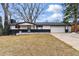 Charming single story home with a well-manicured lawn, front porch, black trim, and two car garage at 6948 W 70Th Ave, Arvada, CO 80003