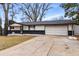 Inviting single-story home featuring a two-car garage, dark brick accents, and a cozy front entrance at 6948 W 70Th Ave, Arvada, CO 80003