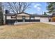 Cozy single-story house with a well-kept lawn, dark brick accents, and an attached two-car garage at 6948 W 70Th Ave, Arvada, CO 80003