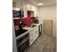 Efficient kitchen layout with stainless steel appliances, a red tile backsplash and white cabinets at 6948 W 70Th Ave, Arvada, CO 80003