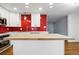 Well-designed kitchen with red backsplash, white cabinetry, a center island, and stainless steel appliances at 6948 W 70Th Ave, Arvada, CO 80003