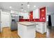 Modern kitchen features stainless steel appliances, white cabinets, butcher block island, and a bold red tiled backsplash at 6948 W 70Th Ave, Arvada, CO 80003