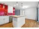 Modern kitchen with red backsplash, a butcher block island, white cabinets, and stainless steel appliances at 6948 W 70Th Ave, Arvada, CO 80003