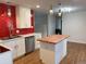 Bright kitchen with stainless steel appliances, red backsplash, and a stylish butcher block island at 6948 W 70Th Ave, Arvada, CO 80003