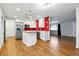 Bright kitchen featuring an island, stainless steel appliances, white cabinets, and red tile backsplash at 6948 W 70Th Ave, Arvada, CO 80003