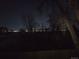 Distant city lights and a dark outline of trees provide a night view of the property at 6948 W 70Th Ave, Arvada, CO 80003