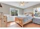 Comfortable bedroom featuring a natural wood bed frame, ceiling fan and bright windows at 15205 W 43Rd Ave, Golden, CO 80403