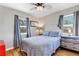 Serene bedroom with a comfortable bed, hardwood floors, curtains, and natural light from two windows at 15205 W 43Rd Ave, Golden, CO 80403