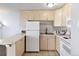 Well-lit kitchen with tile floors, light wood cabinets, white appliances, and bar-top counter at 2500 S York St # 410, Denver, CO 80210