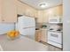 Bright kitchen featuring white appliances, light wood cabinets, and tile flooring at 2500 S York St # 410, Denver, CO 80210