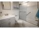 Bathroom featuring a gray vanity, toilet, and bath/shower combo with glass doors at 11205 Holly St, Thornton, CO 80233