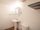 Cozy half bath with pedestal sink, medicine cabinet, and sleek, modern fixtures create a tranquil space at 11205 Holly St, Thornton, CO 80233