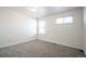 Bright bedroom with neutral carpet, two windows, and plenty of natural light at 11205 Holly St, Thornton, CO 80233