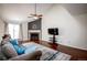 Cozy living room featuring a fireplace, a ceiling fan, and a large window at 11205 Holly St, Thornton, CO 80233