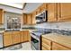 Bright kitchen features wood cabinets, modern appliances, and stylish tile backsplash at 14204 E Radcliff Cir, Aurora, CO 80015
