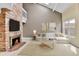 Staged living room with brick fireplace, comfortable seating, and stylish decor at 14204 E Radcliff Cir, Aurora, CO 80015
