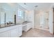 Modern bathroom with double vanity, walk-in shower, and neutral tile at 4652 Windmill Dr, Brighton, CO 80601