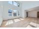 Bright living room with soaring ceilings, large windows, and light wood floors at 4652 Windmill Dr, Brighton, CO 80601