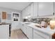 Bright kitchen features white cabinets, mosaic backsplash, and new flooring at 1682 S Kline Way, Lakewood, CO 80232