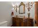 Elegant powder room with custom wood vanity and decorative mirror and sconces at 65 Royal Ann Dr, Englewood, CO 80111