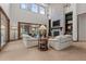 Cozy living room featuring a stone fireplace, high ceilings, large windows, and comfortable seating at 65 Royal Ann Dr, Englewood, CO 80111