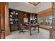 Home office with custom built-ins, hardwood desk, and large window offering natural light and outside views at 65 Royal Ann Dr, Englewood, CO 80111