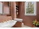 Stylish powder room with elegant mirror, decorative shelving, and unique sink and faucet fixtures at 65 Royal Ann Dr, Englewood, CO 80111