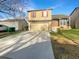 Traditional two story home featuring a two car garage, manicured lawn, and mature landscaping at 2875 S Espana Ct, Aurora, CO 80013
