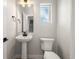 Cozy powder bathroom featuring modern fixtures, pedestal sink, and natural light at 888 S Valentia St # 104, Denver, CO 80247