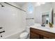 Bathroom with a tub/shower, vanity with dark wood cabinets, white counter and backsplash, and a modern mirror at 888 S Valentia St # 104, Denver, CO 80247