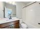 Clean bathroom with a white tiled shower-tub, sleek fixtures, and a wood-grain vanity with a bright white countertop at 888 S Valentia St # 104, Denver, CO 80247
