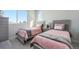 Bedroom showcasing two twin beds with soft pink bedding and a large window providing ample natural light at 888 S Valentia St # 104, Denver, CO 80247