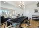 Open-concept dining area with a modern chandelier and a long black table, perfect for entertaining at 888 S Valentia St # 104, Denver, CO 80247